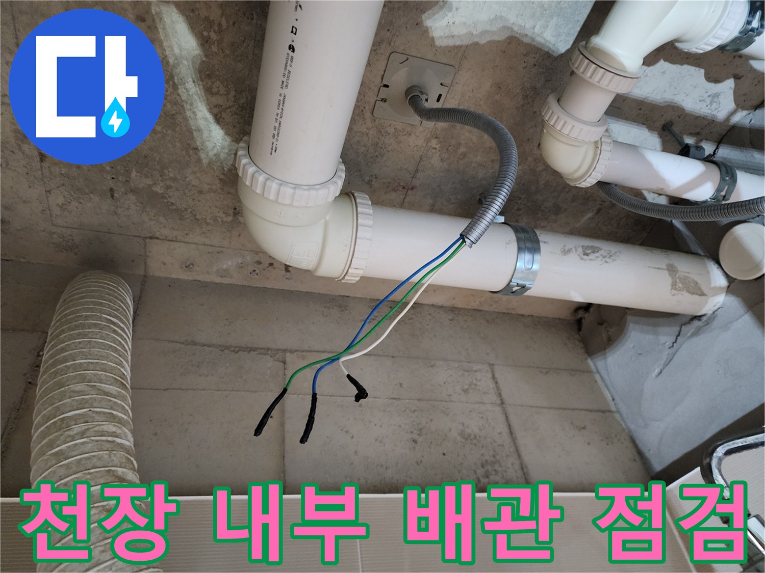 천장 속 PVC 파이프와 전기 전선이 노출된 현장 사진입니다.