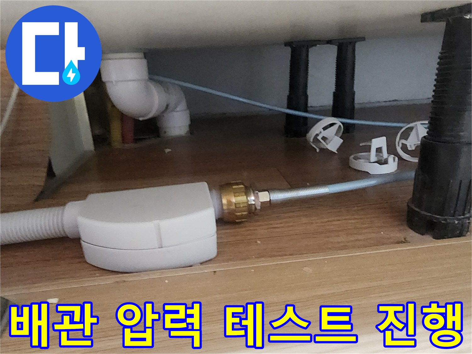 싱크대 하부 배관에 연결된 공압 테스트용 부속품