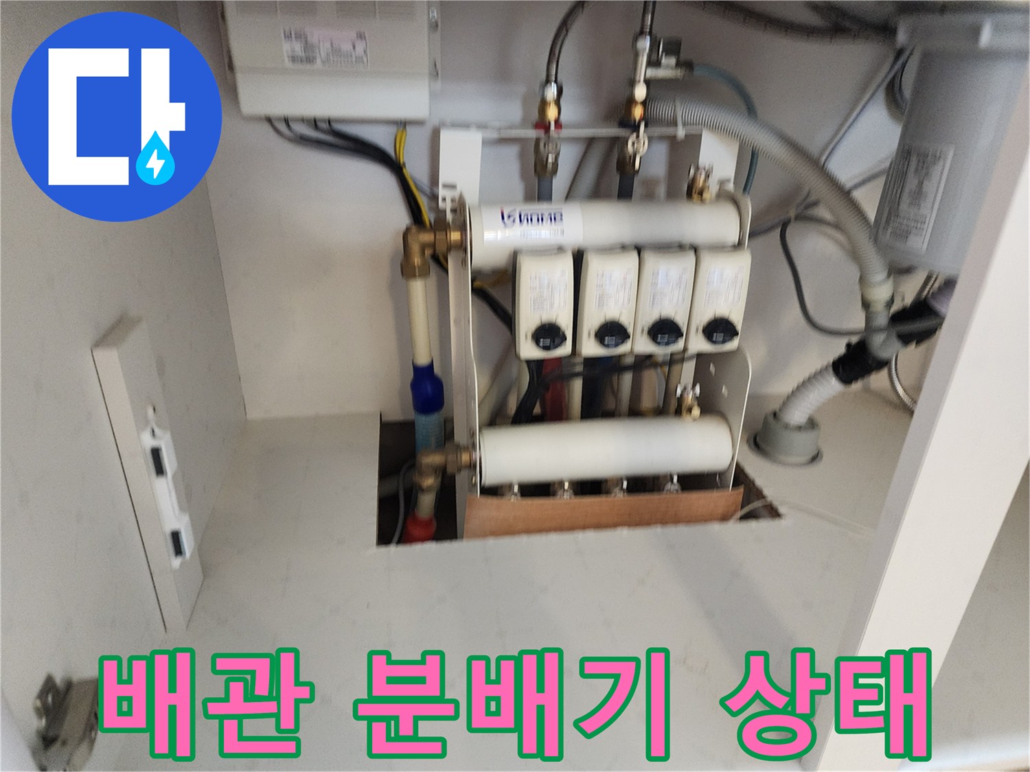 주방-하부장에-설치된-다중-분배기-및-연결-배관-근접-촬영