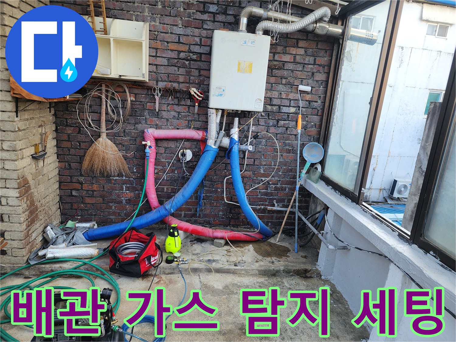 벽돌 벽면 아래 배관에 연결된 누수 탐지용 호스들
