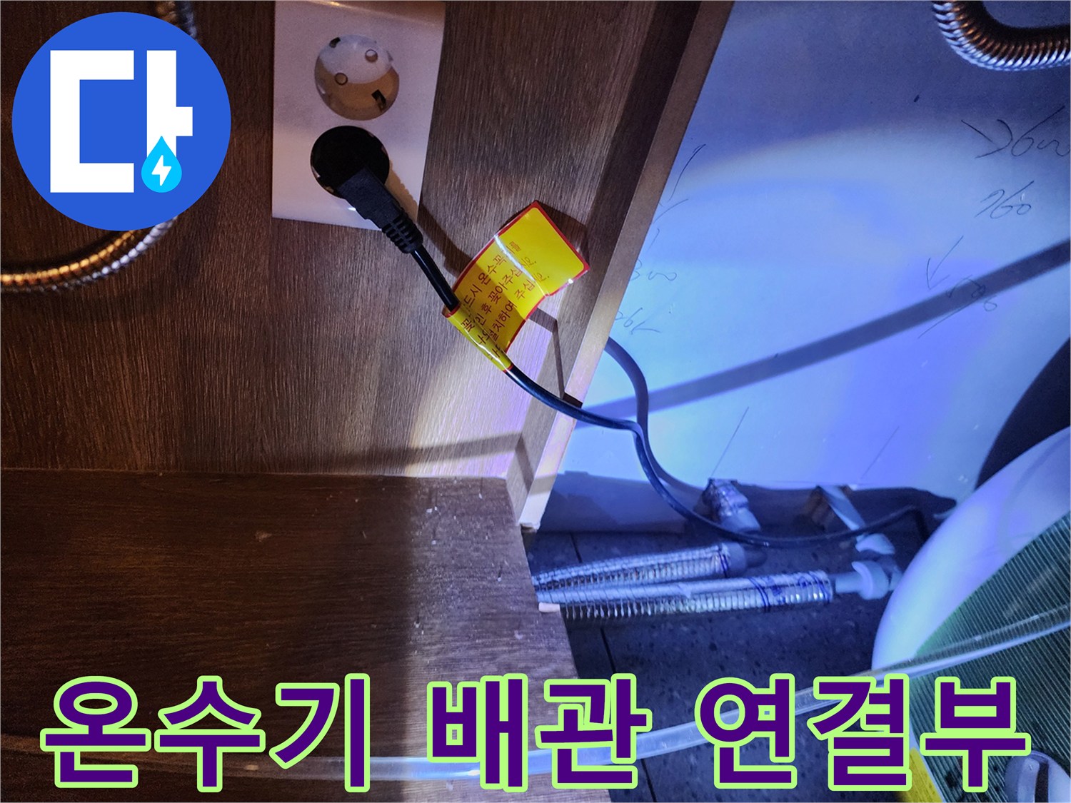 전기 플러그와 하부장 내부의 온수기 배관 라인-누수 지점 추적 중