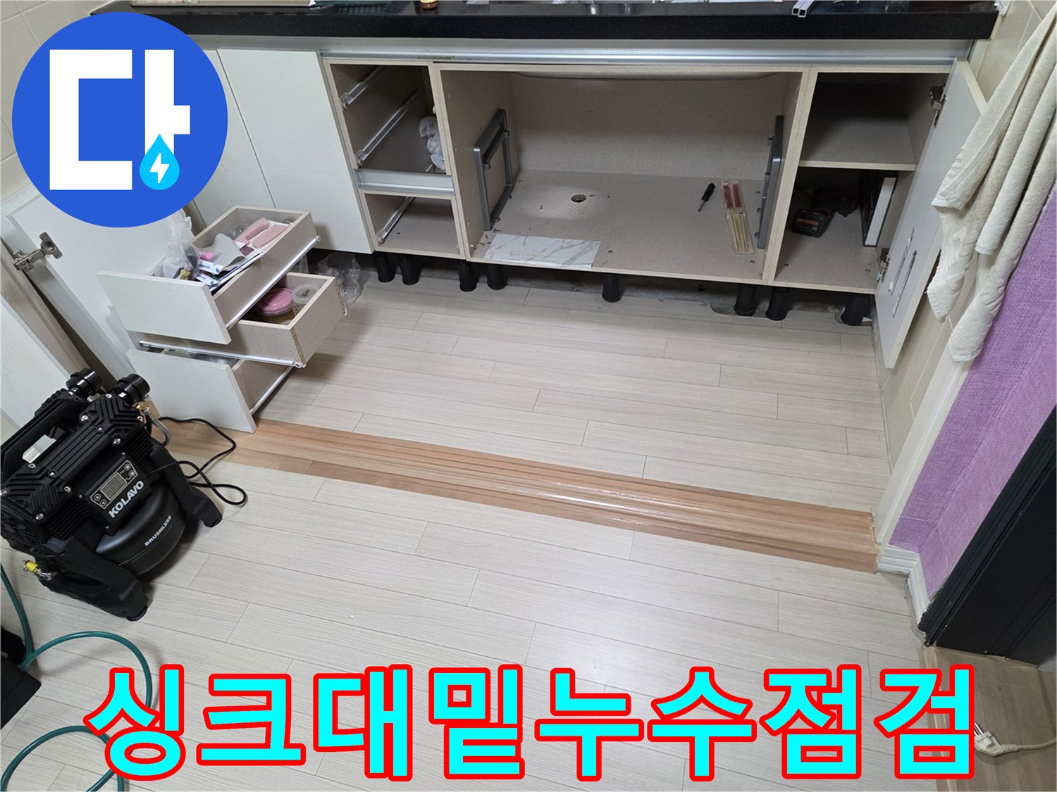 누수 지점을 찾기 위해 싱크대 하부장을 정리해 둔 현장 사진입니다.
