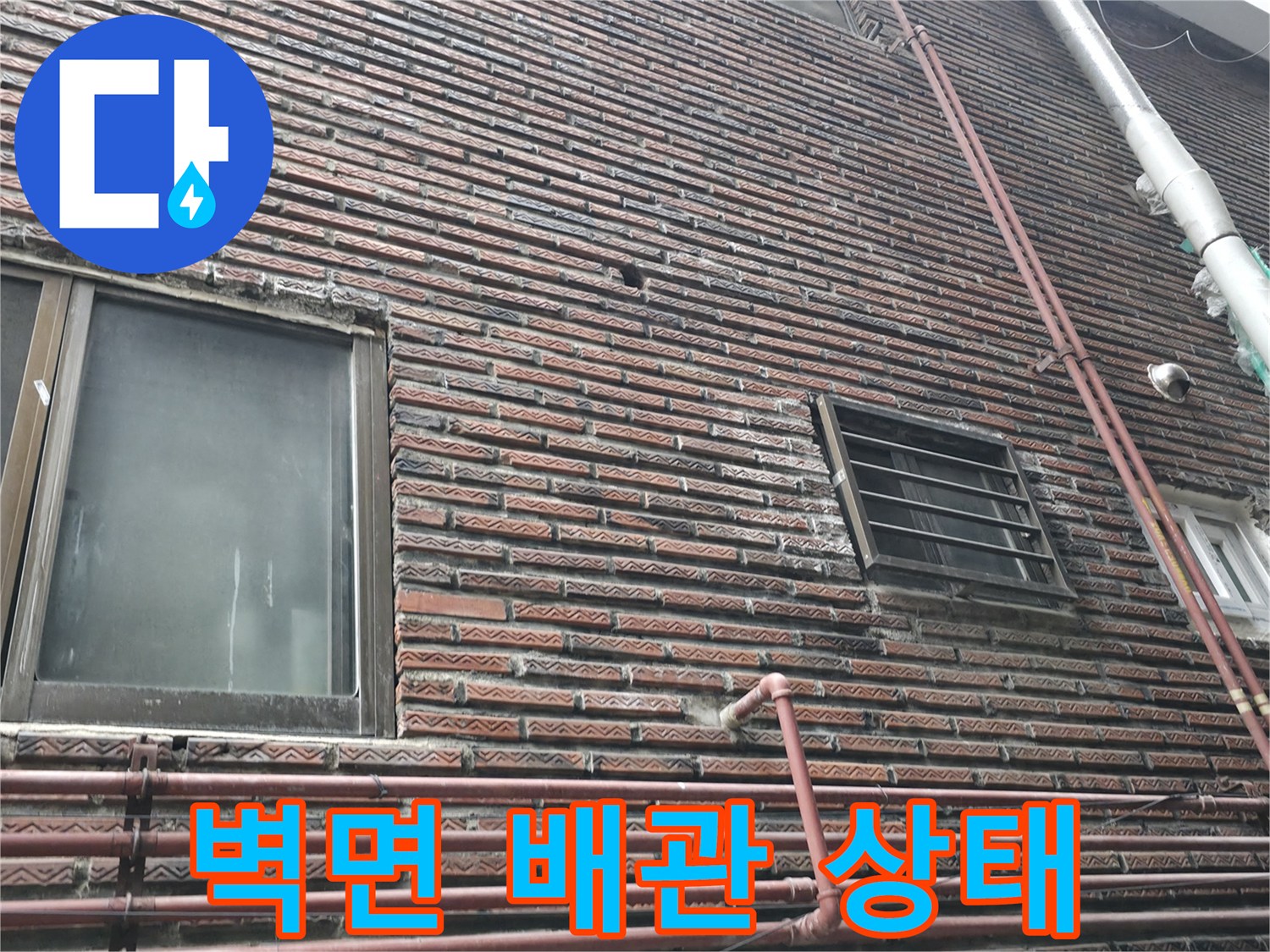 창문 아래쪽 벽돌 외벽에 설치된 배관들의 배치 상태