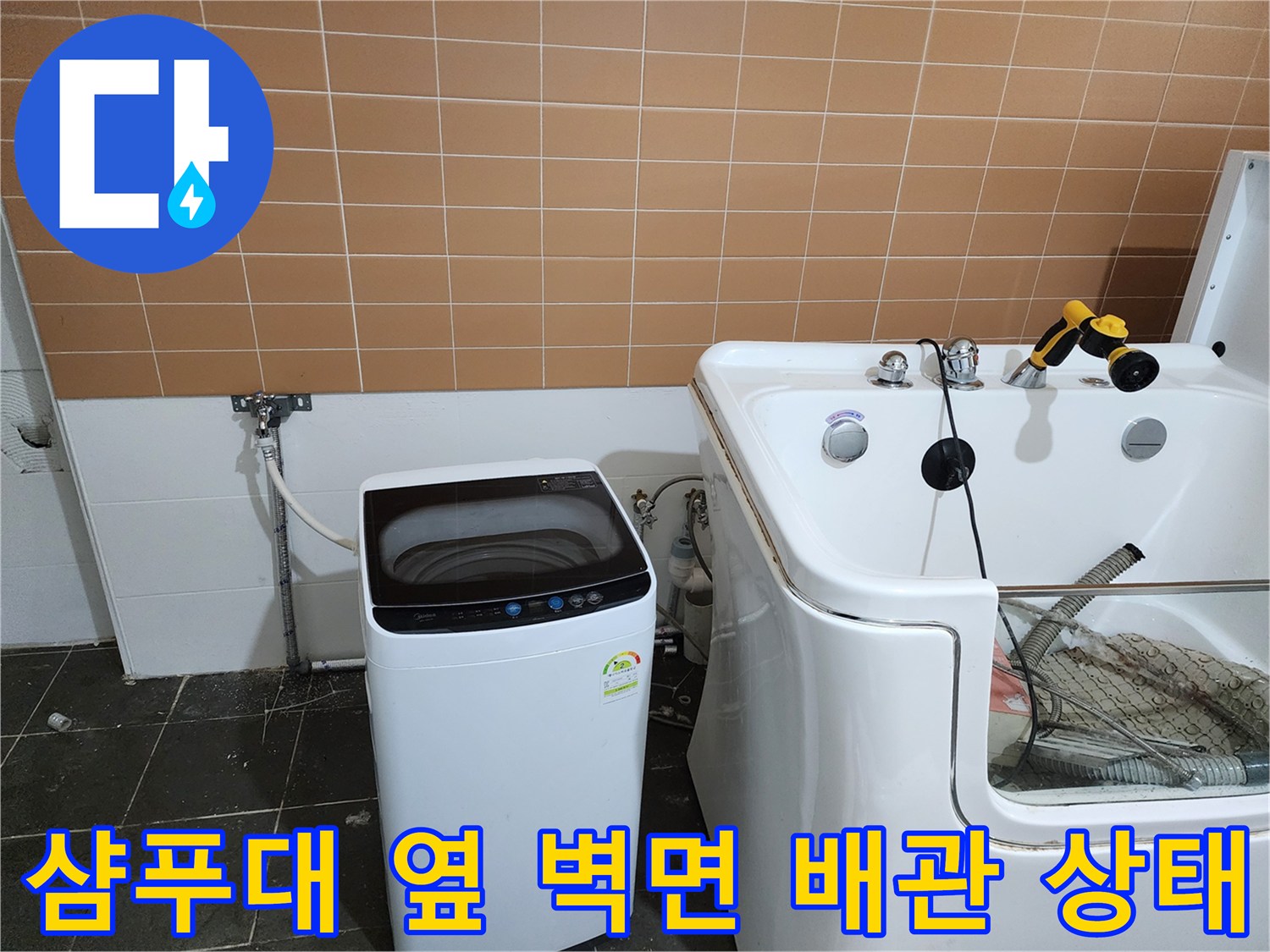 벽면 수도 밸브와 세탁기 급수 호스 및 샴푸대 하단부 상세 모습