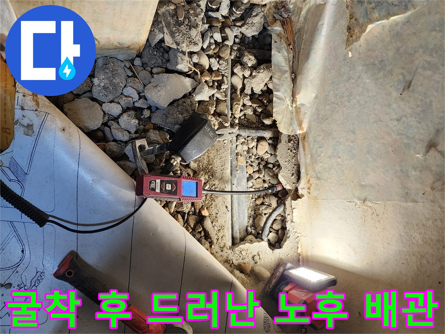 바닥을 파낸 자리에-드러난 부식된 금속 배관과 탐지 장비의 모습