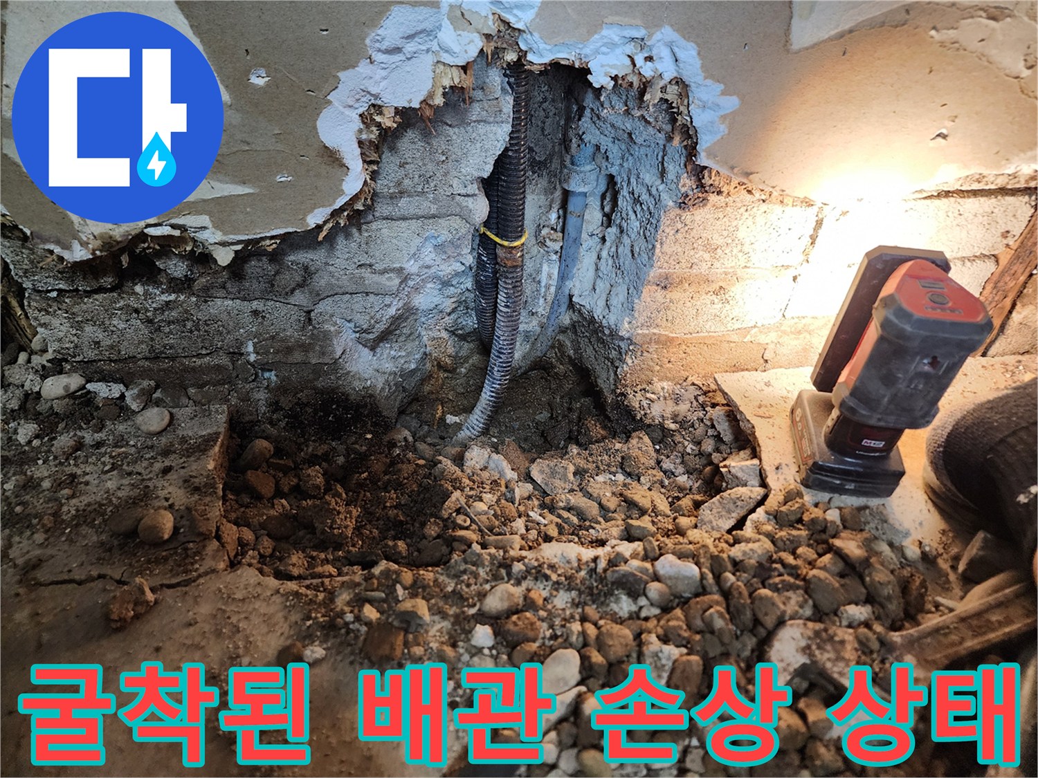 배관 주변의 젖은 자갈과 파손된 배관 연결부