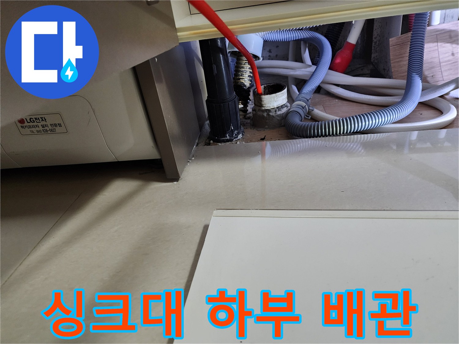 싱크대 아래쪽 굵은 배수 호스와 연결된 관의 누수 지점 근접 촬영