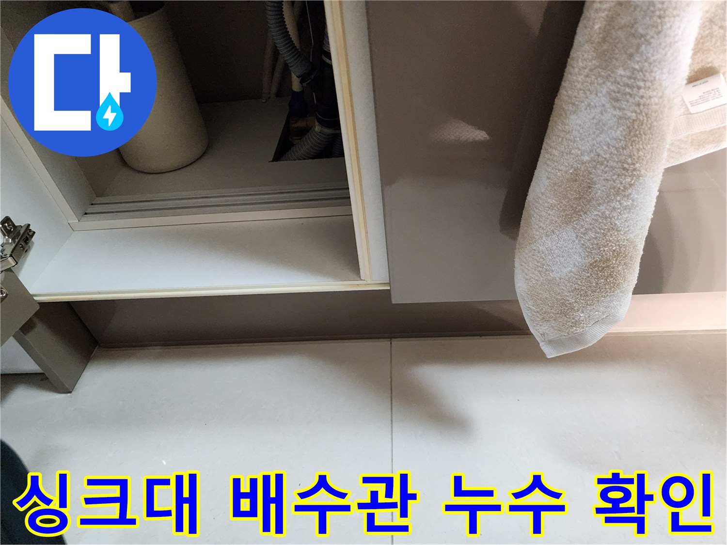싱크대 하부장 내부의 배수 호스와 연결 부위 상태를 보여주는 사진
