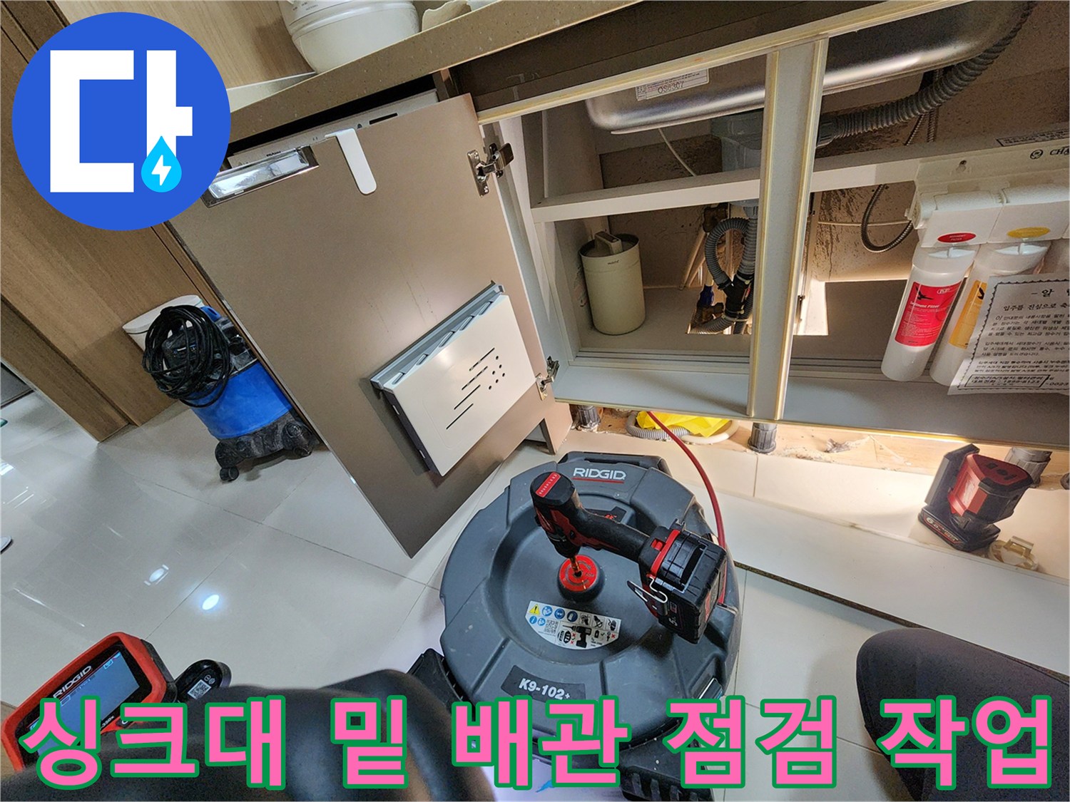 작업을 위해 정리된 싱크대 하단 배관 부위와 장비들