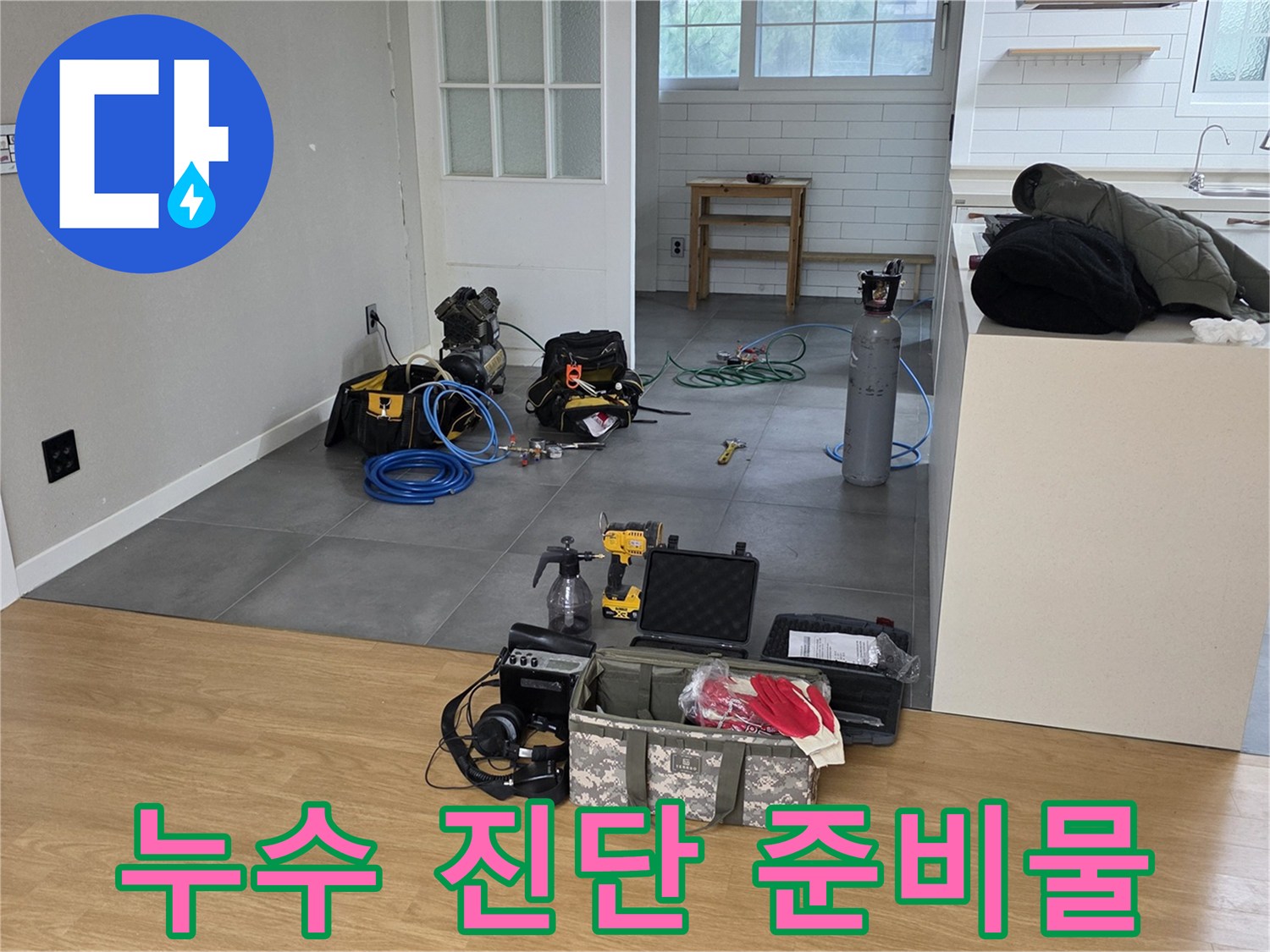 거실 바닥에 배치된 누수 탐색용 가스 공급 장치와 공구 세트