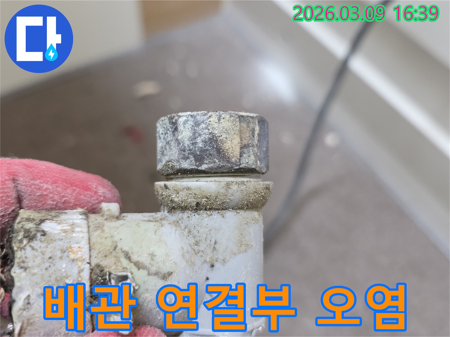 누수-점검-중-발견된-오래되고-오염된-배관-연결부위를-확대하여-보여주는-사진입니다