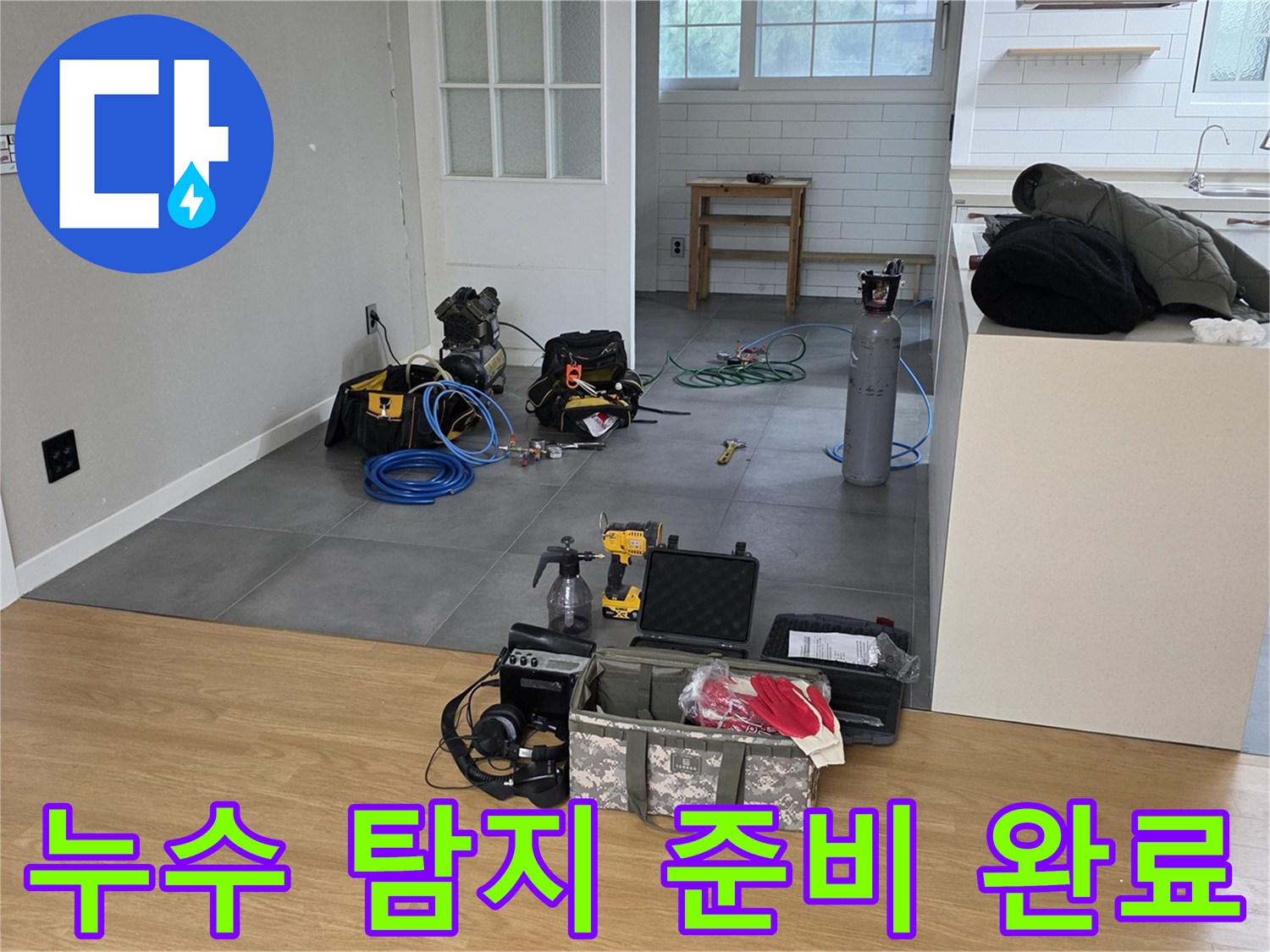 누수 지점 탐지를 위해 거실 바닥에 배치된 가스 탐지기와 공구 상자