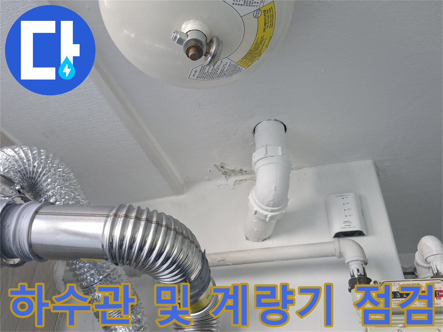 가스계량기와 흰색 배관이 연결된 세탁실 벽면 모습