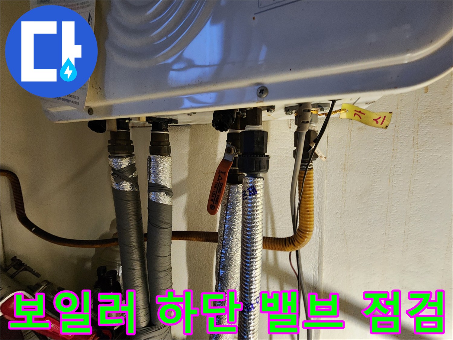 주황색-밸브가-설치된-보일러-하단-배관-연결-부위의-근접-사진입니다.
