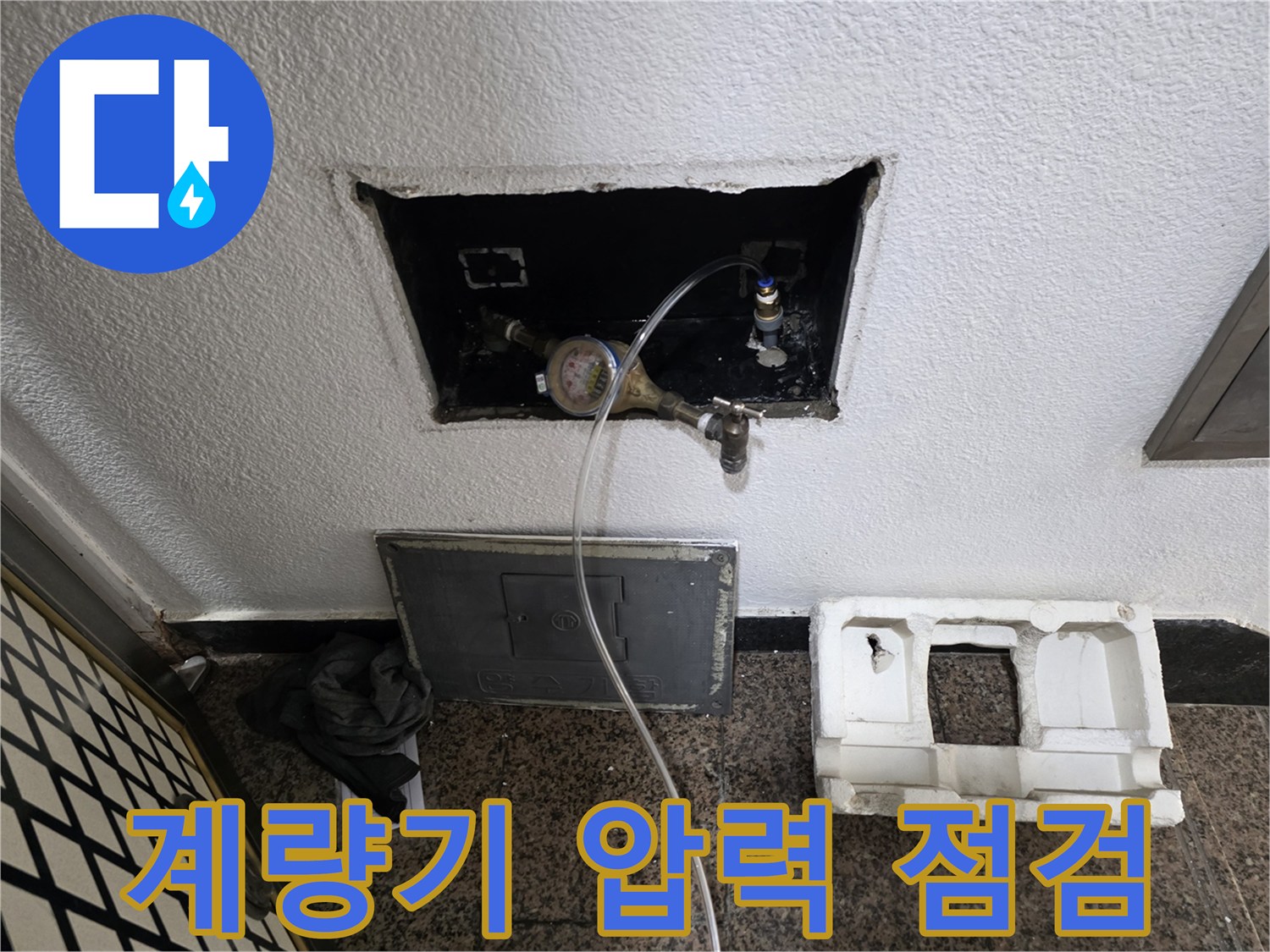 수도 계량기에 압력계를 연결하여 배관의 기밀성을 확인하는 모습