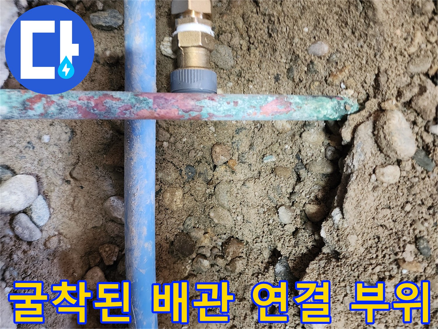 바닥 흙을 제거하여 드러난 파란색 수도 배관의 교차 지점