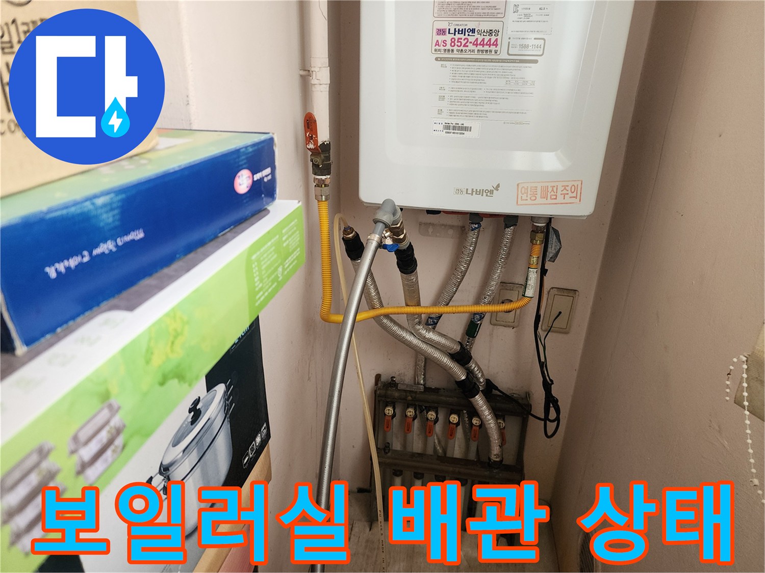 보일러 하부에 연결된 여러 개의 급수 및 온수 배관 모습