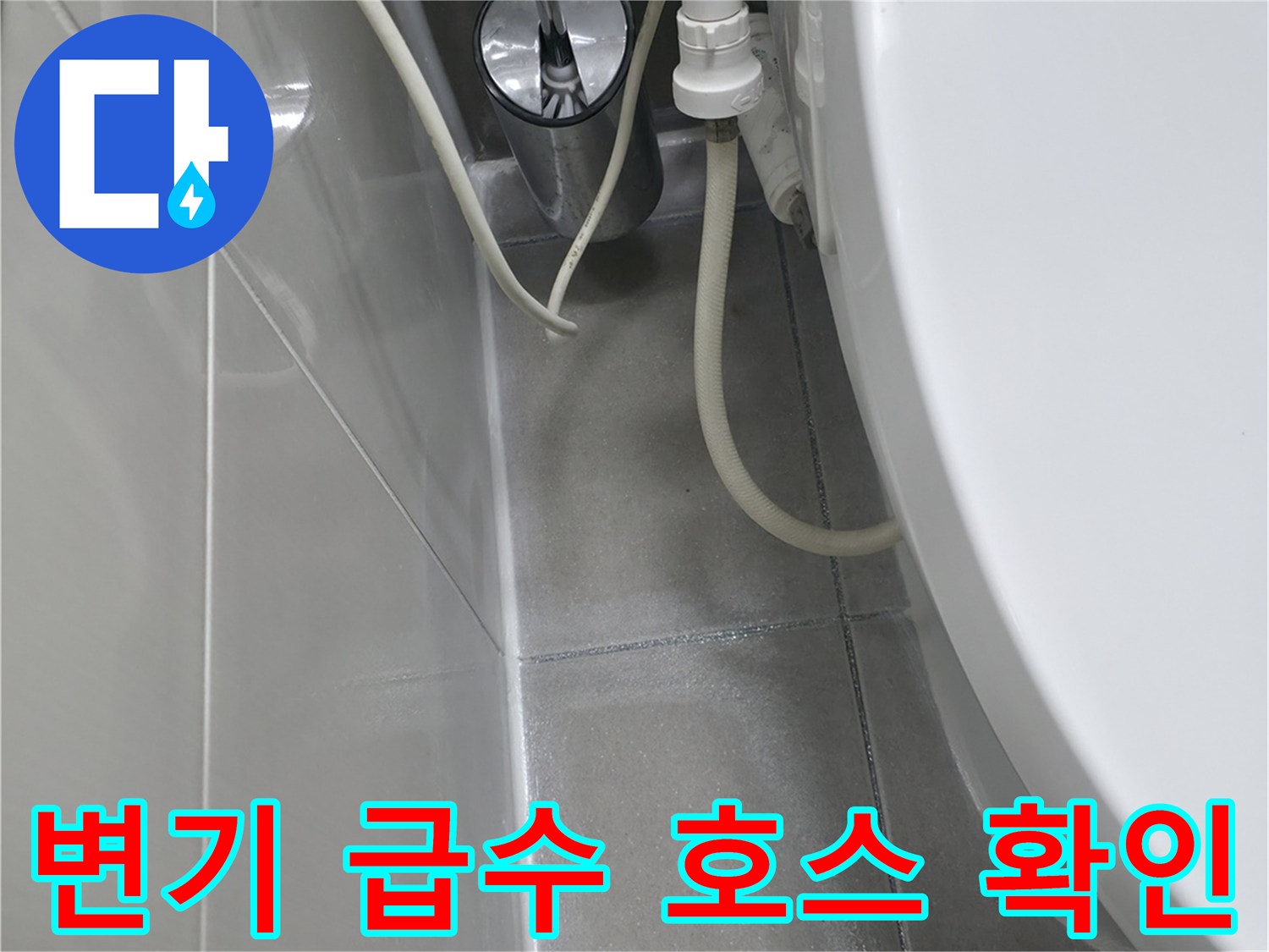 변기 하단부의 급수 밸브와 연결된 흰색 호스의 상태를 보여주는 사진입니다.