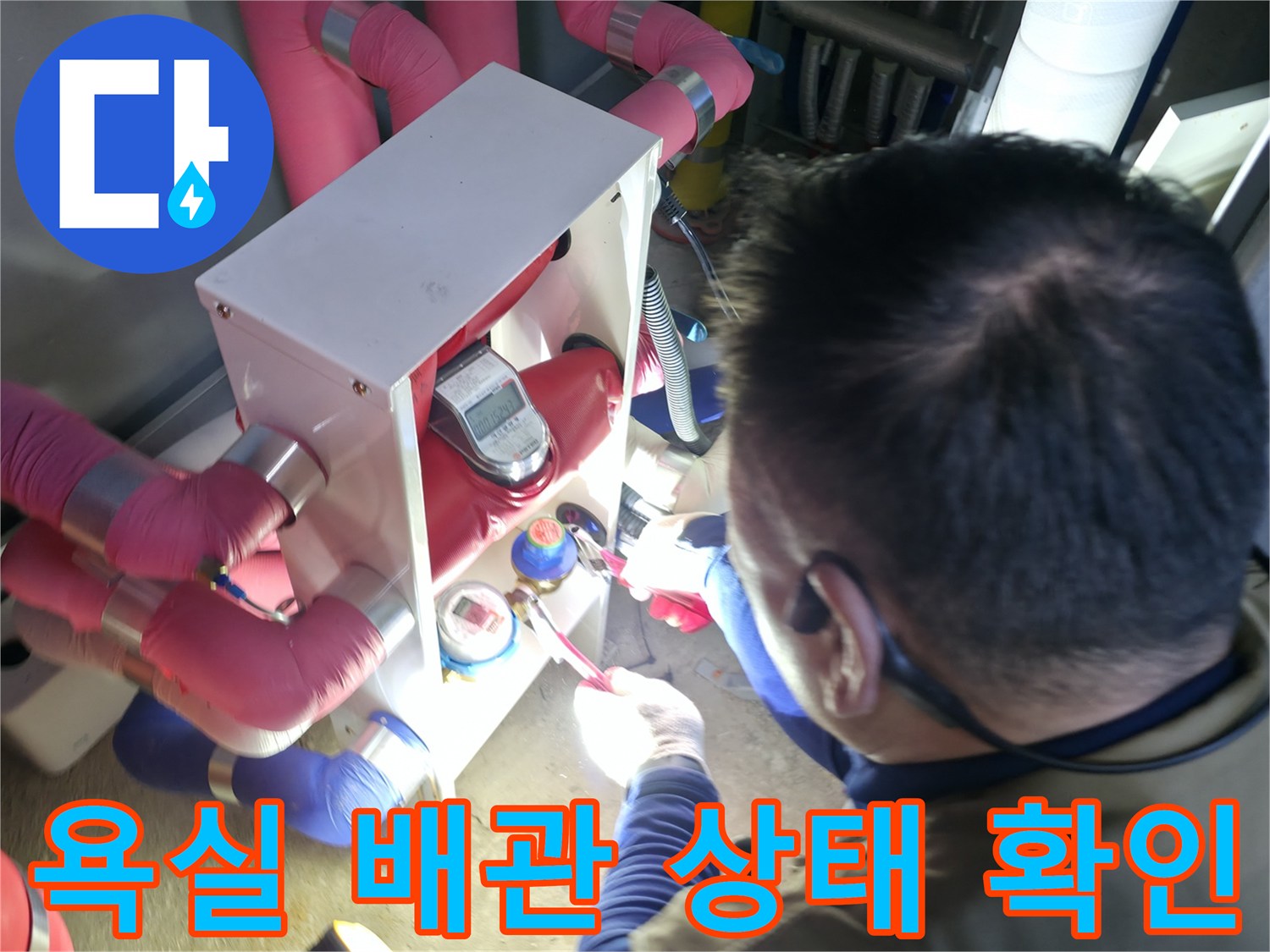 복잡하게 얽힌 분홍색 배관과 밸브 장치를 점검하는 엔지니어의 모습