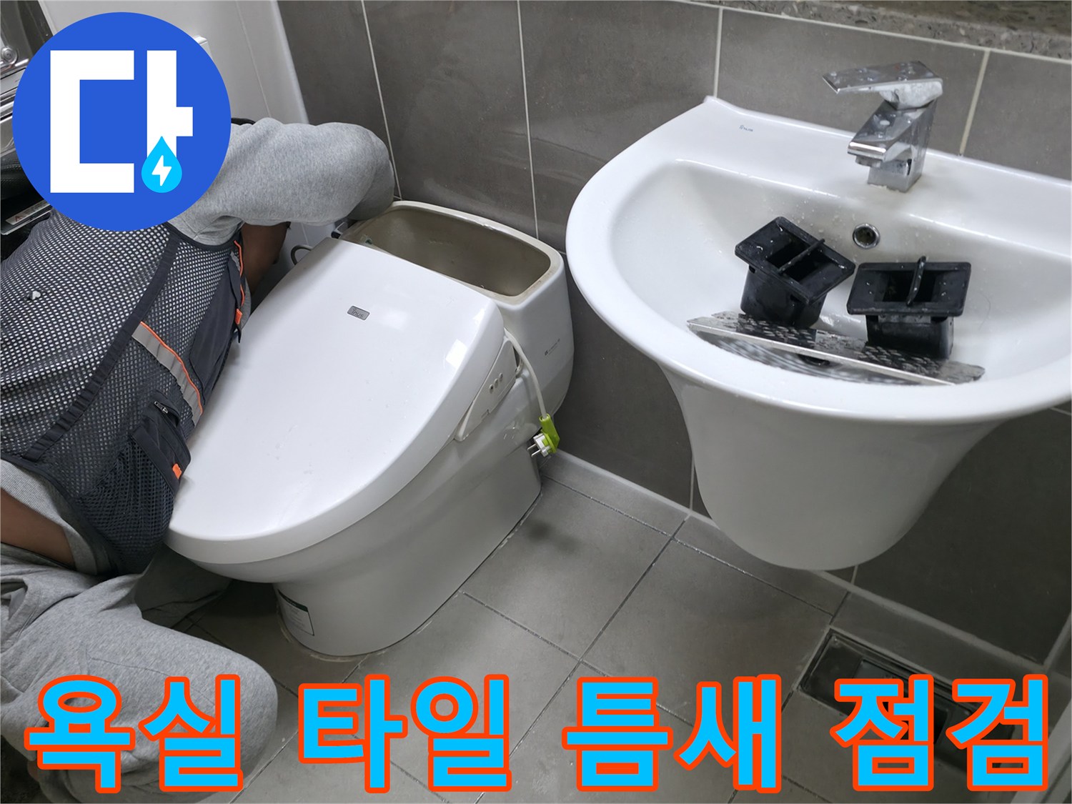세면대와 변기 사이 타일 줄눈 상태를 관찰하는 모습