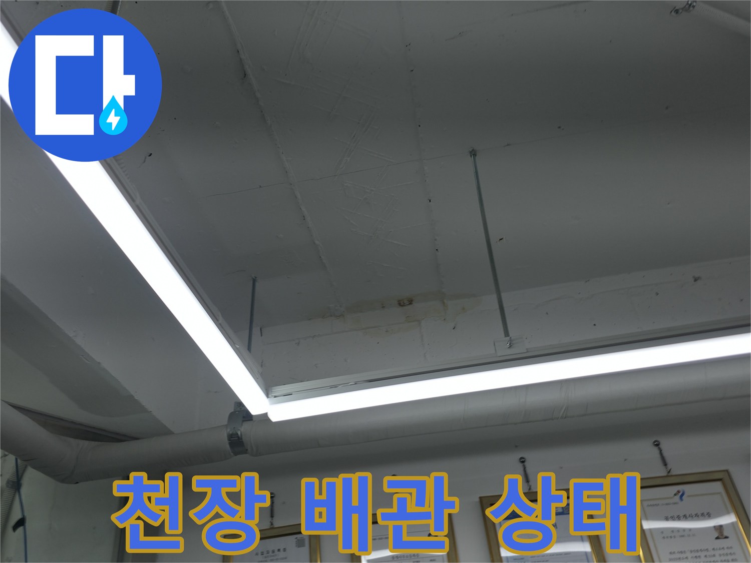 흰색 배관과 조명이 설치된 천장 내부의 모습