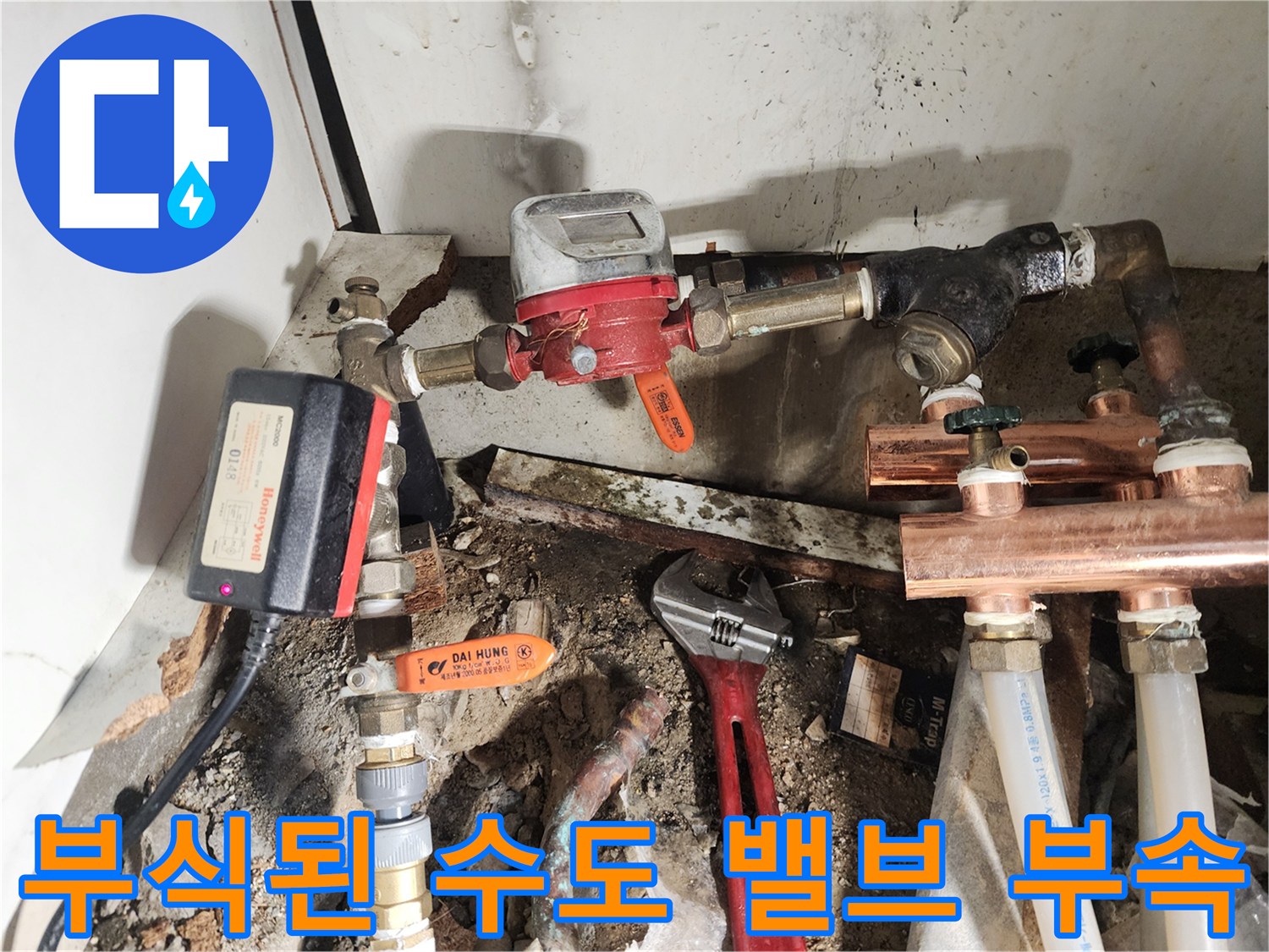 싱크대 하부의 노후된 금속 배관과 압력 조절기