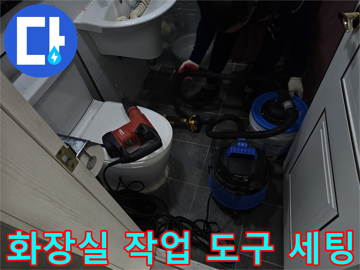 변기 근처의 누수를 해결하기 위해 배치된 청소기와 전동 드릴입니다.