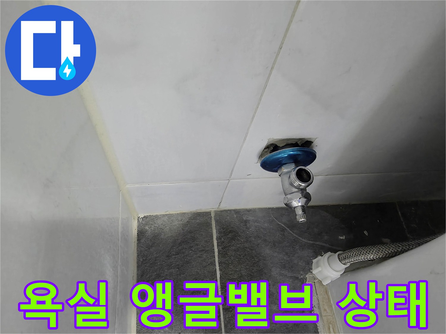 화장실 타일 벽에 설치된 은색 앵글밸브와 배관 연결부