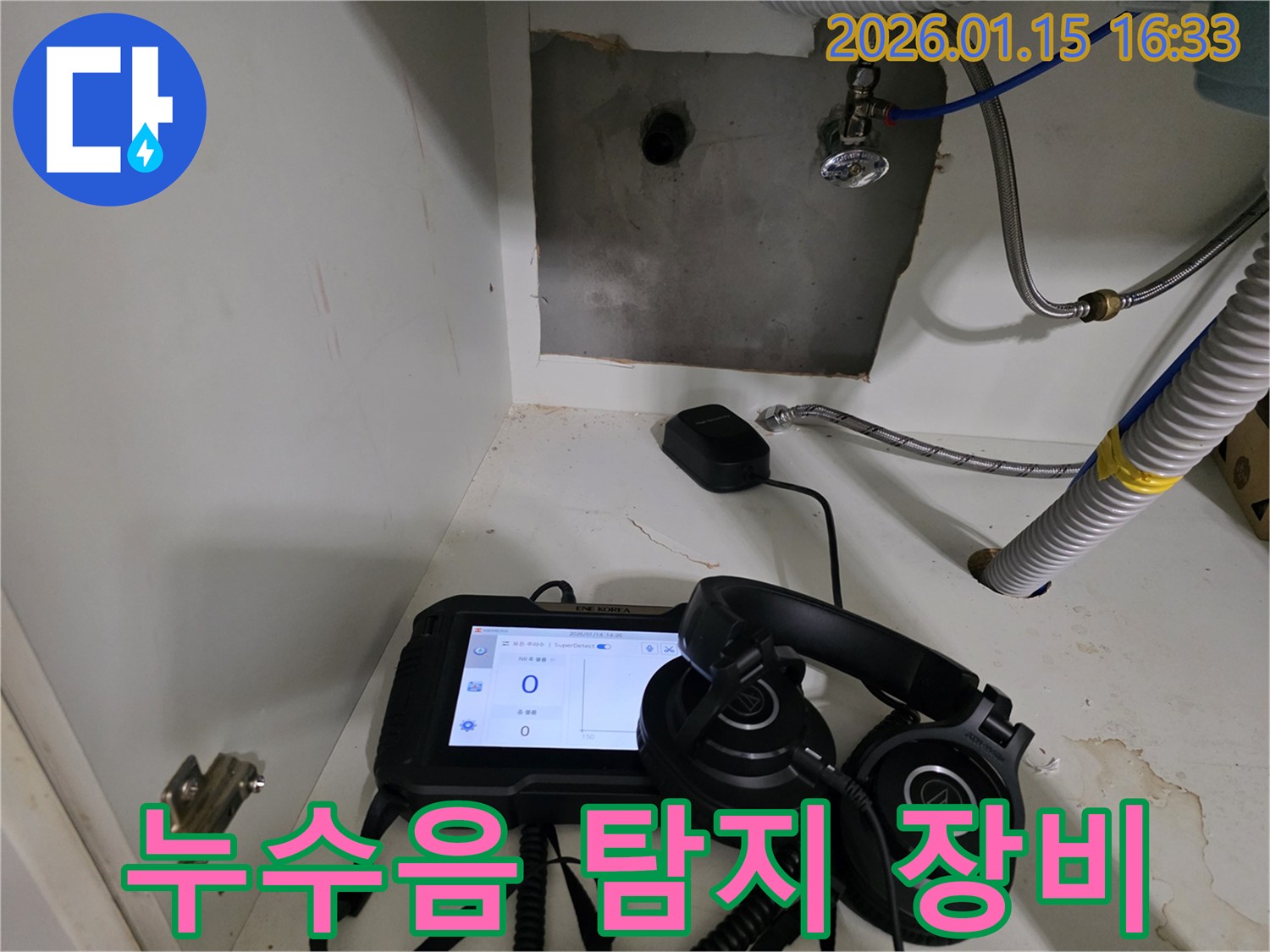 싱크대 하부에서 누수음을 정밀하게 탐지하기 위해 전문 장비를 사용 중입니다.