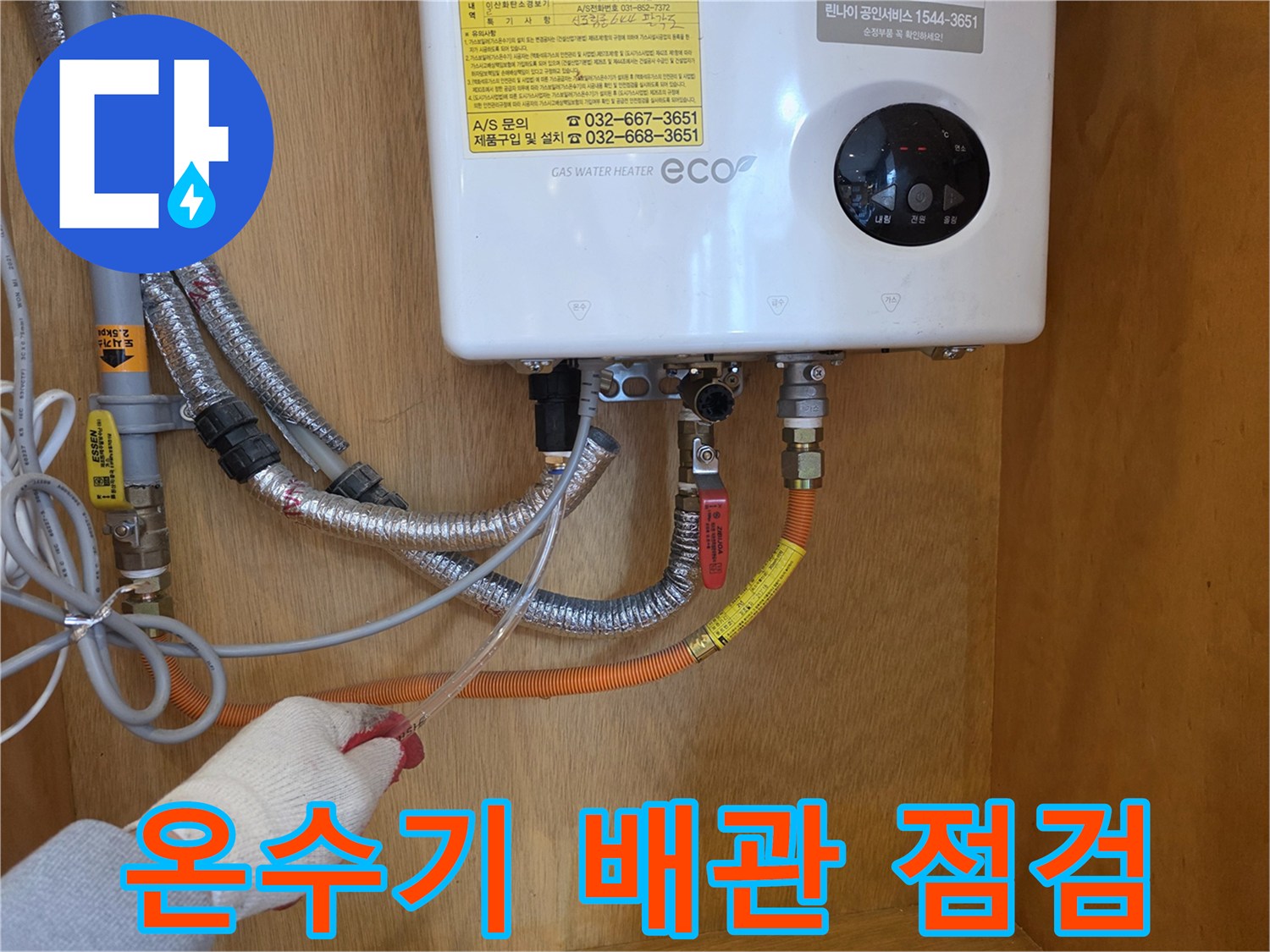 가스 온수기 하단 연결 부위의 배관 상태를 확인하는 모습