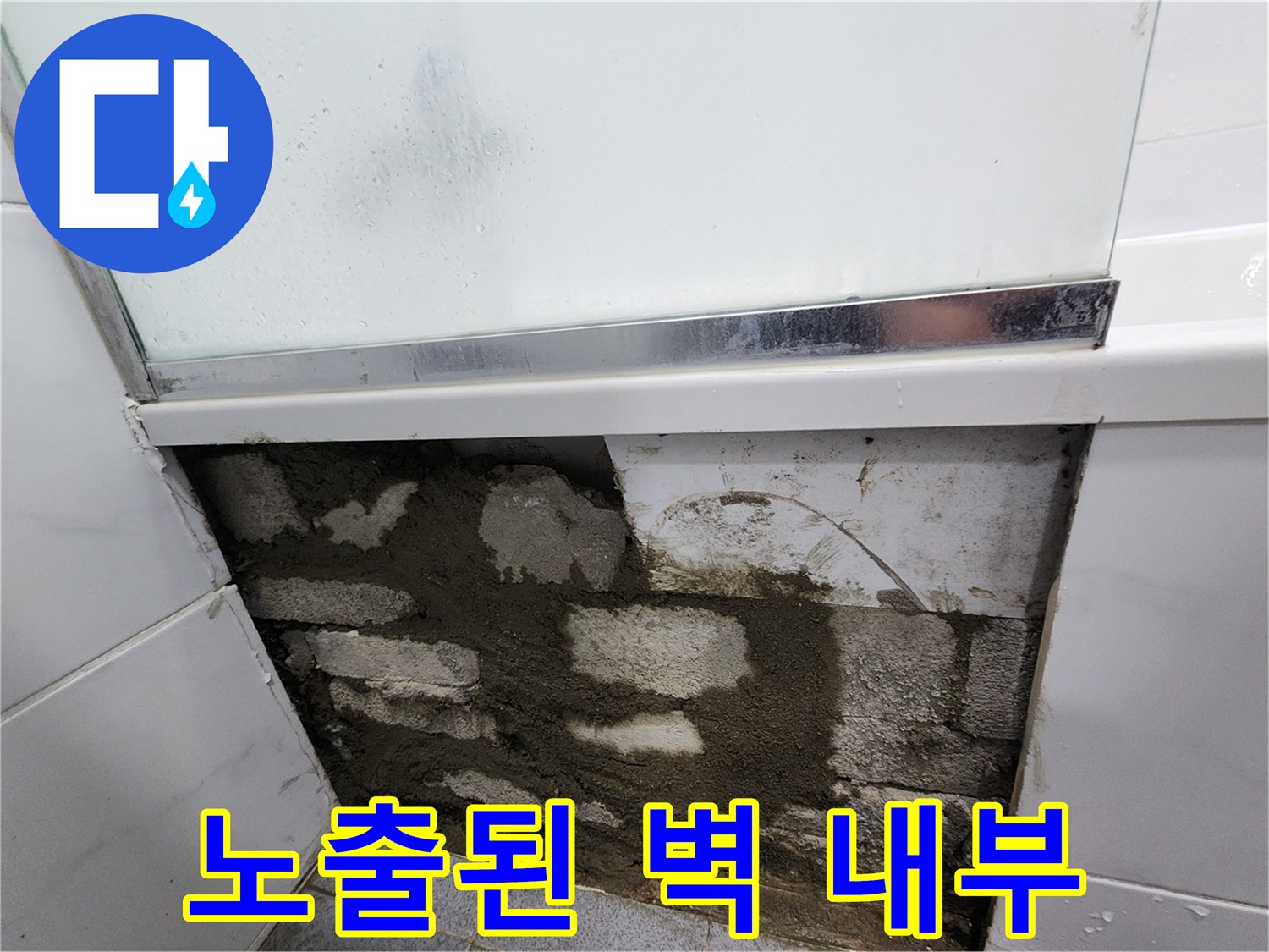 누수 확인을 위해 타일을 제거하고 드러낸 거친 시멘트 벽면
