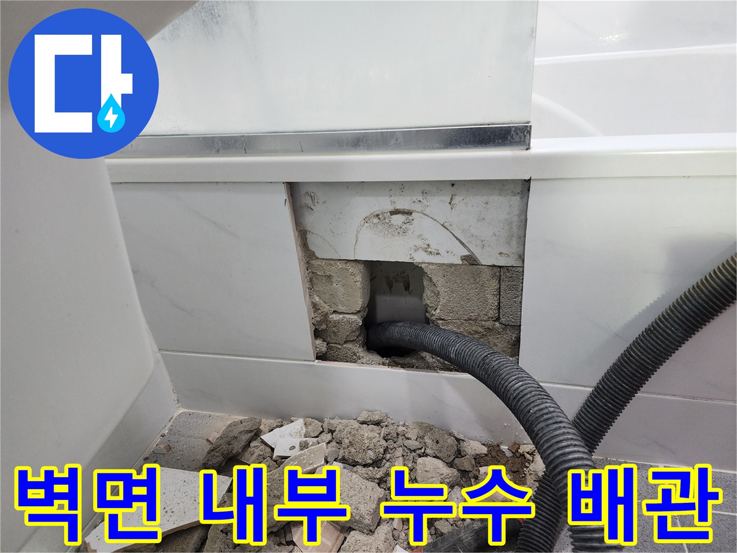 타일 제거 후 노출된 파손된 검은색 주름관 배관