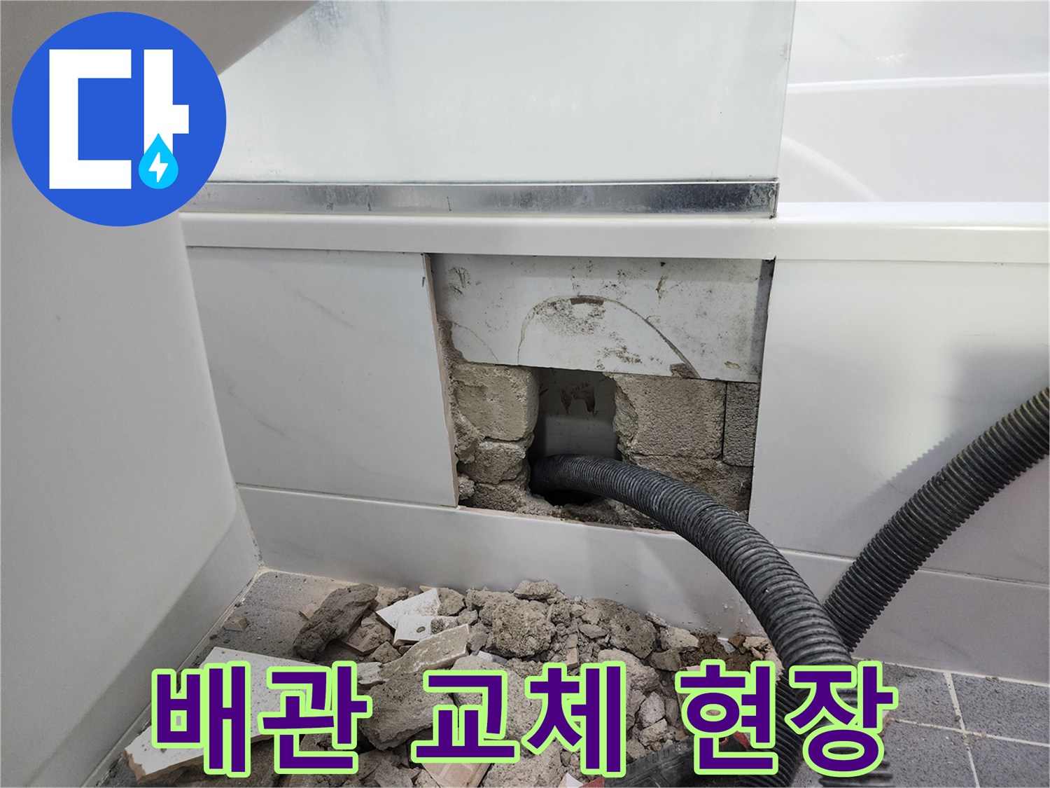 타일 제거 후 드러난 손상된 검은색 배수 배관