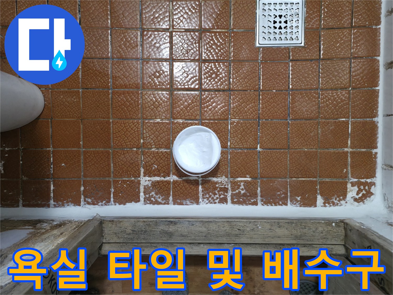 갈색 타일로 덮인 바닥 - 하얀색 배수구와 배관 부위
