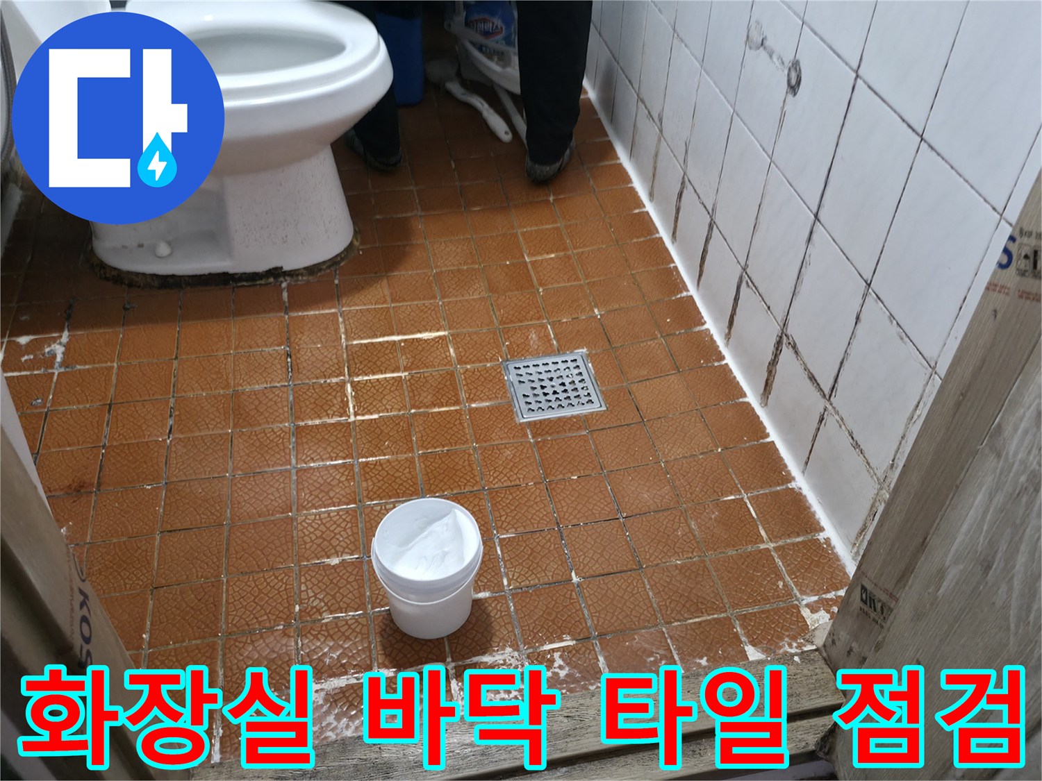 변기 아래와 배수구 주변의 젖은 타일 상태 사진