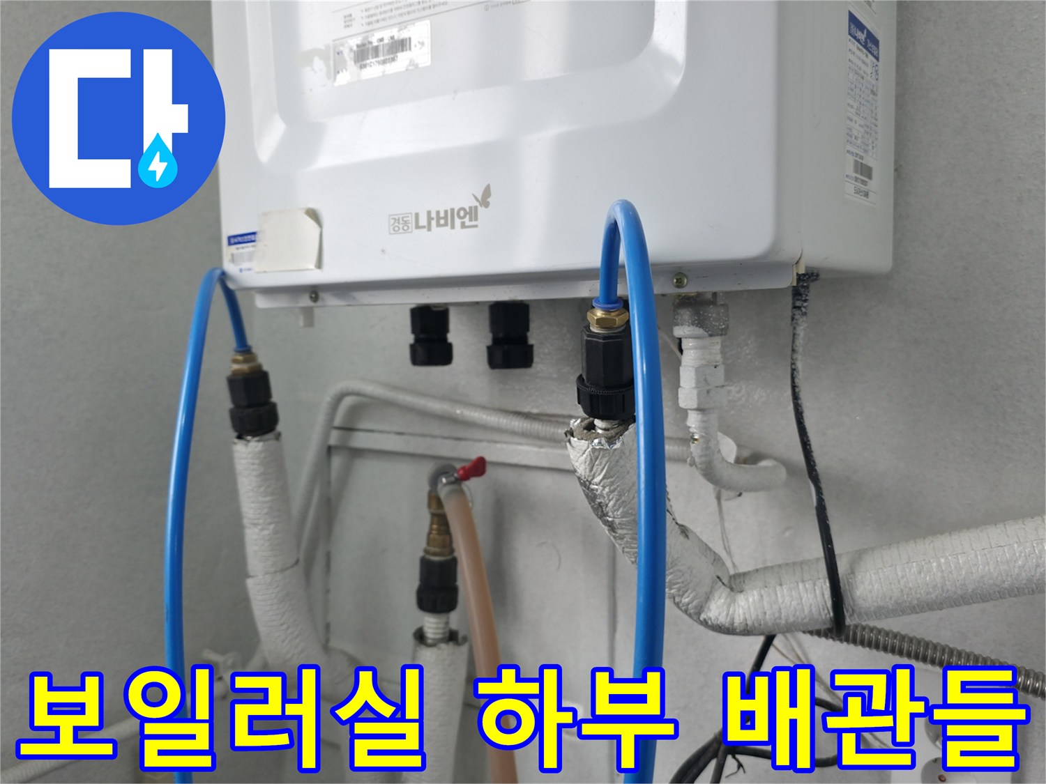 보일러 아래쪽으로 연결된 파란색 호스와 흰색 배관들의 배열