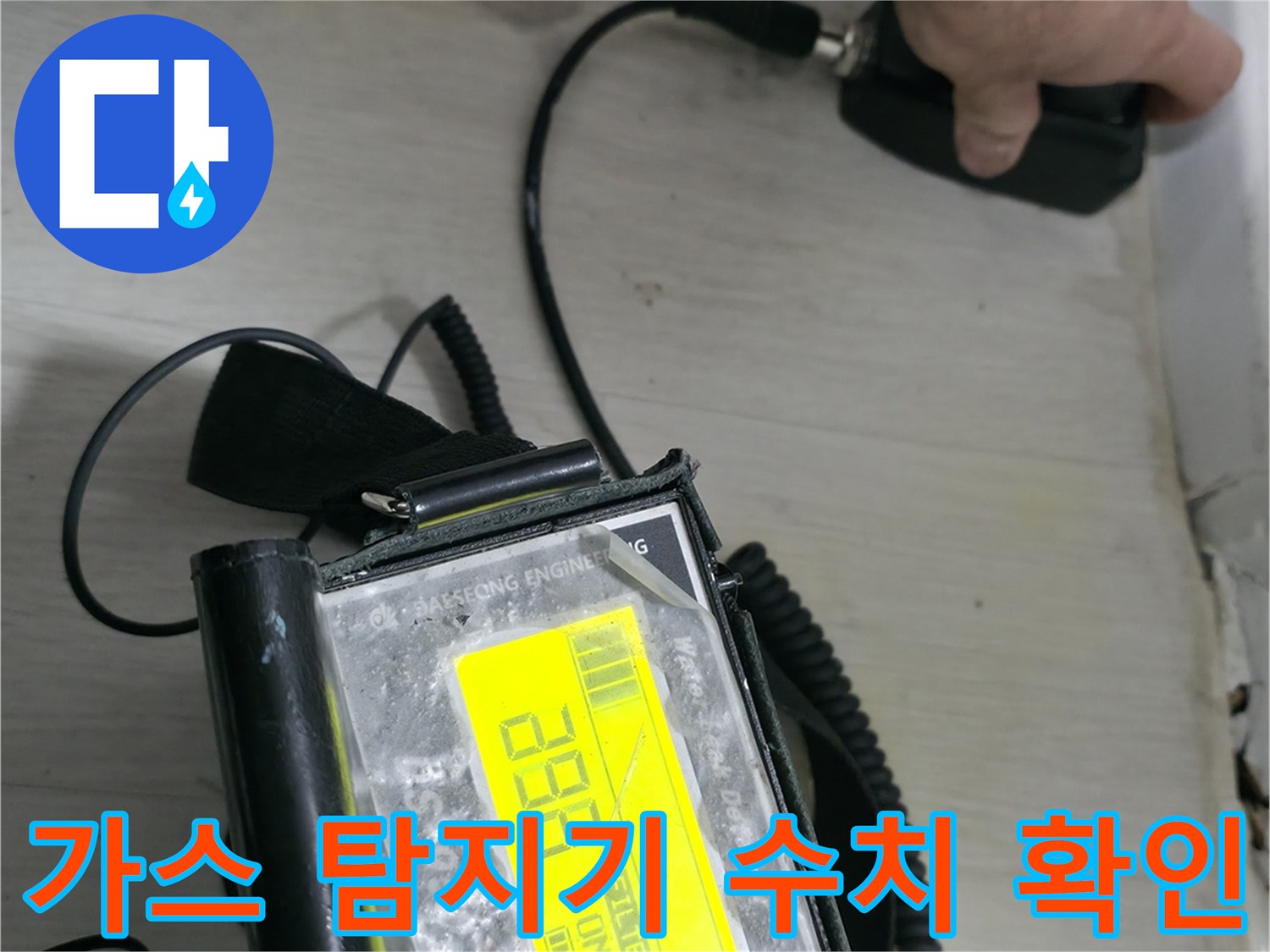 숫자가 표시된 가스 탐지기로 배관의 누출 여부를 점검하는 모습입니다.