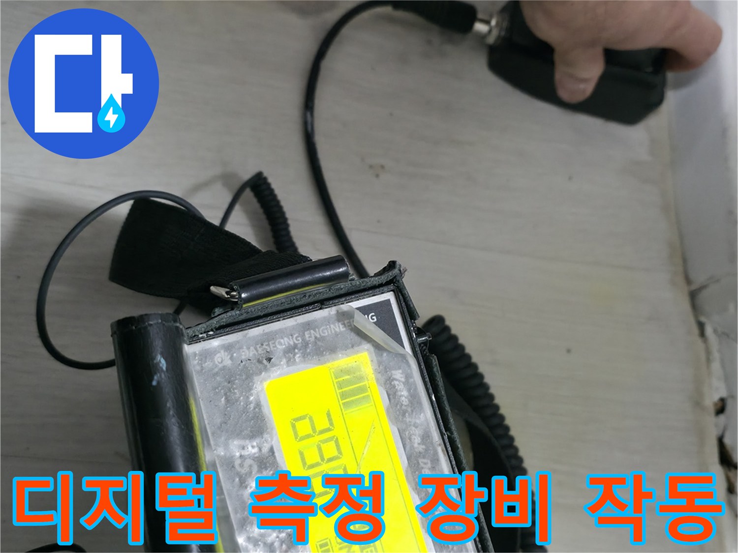 숫자가 표시된 디지털 계측기를 손으로 잡고 점검하는 장면