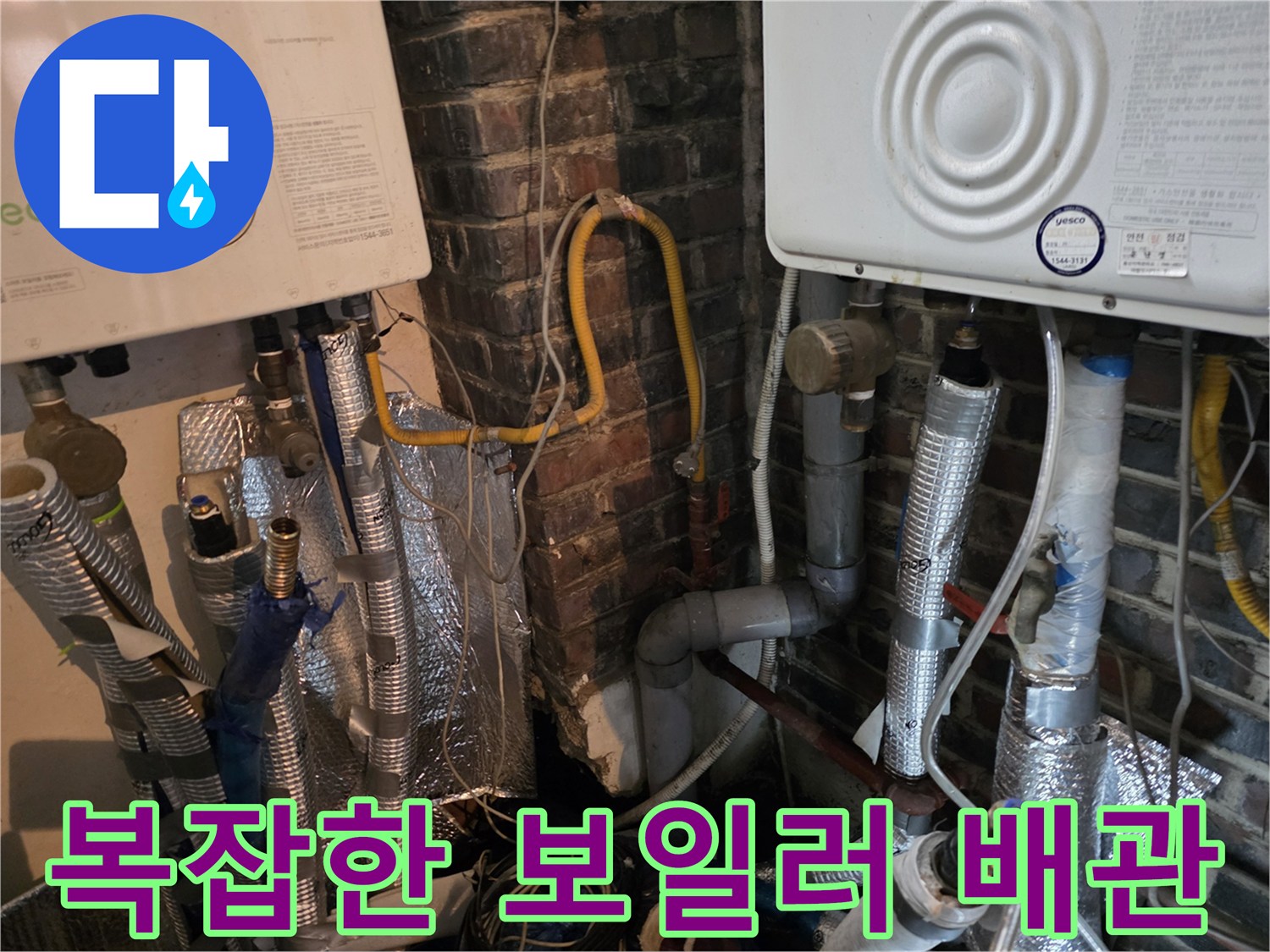 은색 보온재와 노란색 호스가 연결된 보일러 하단 배관 구조