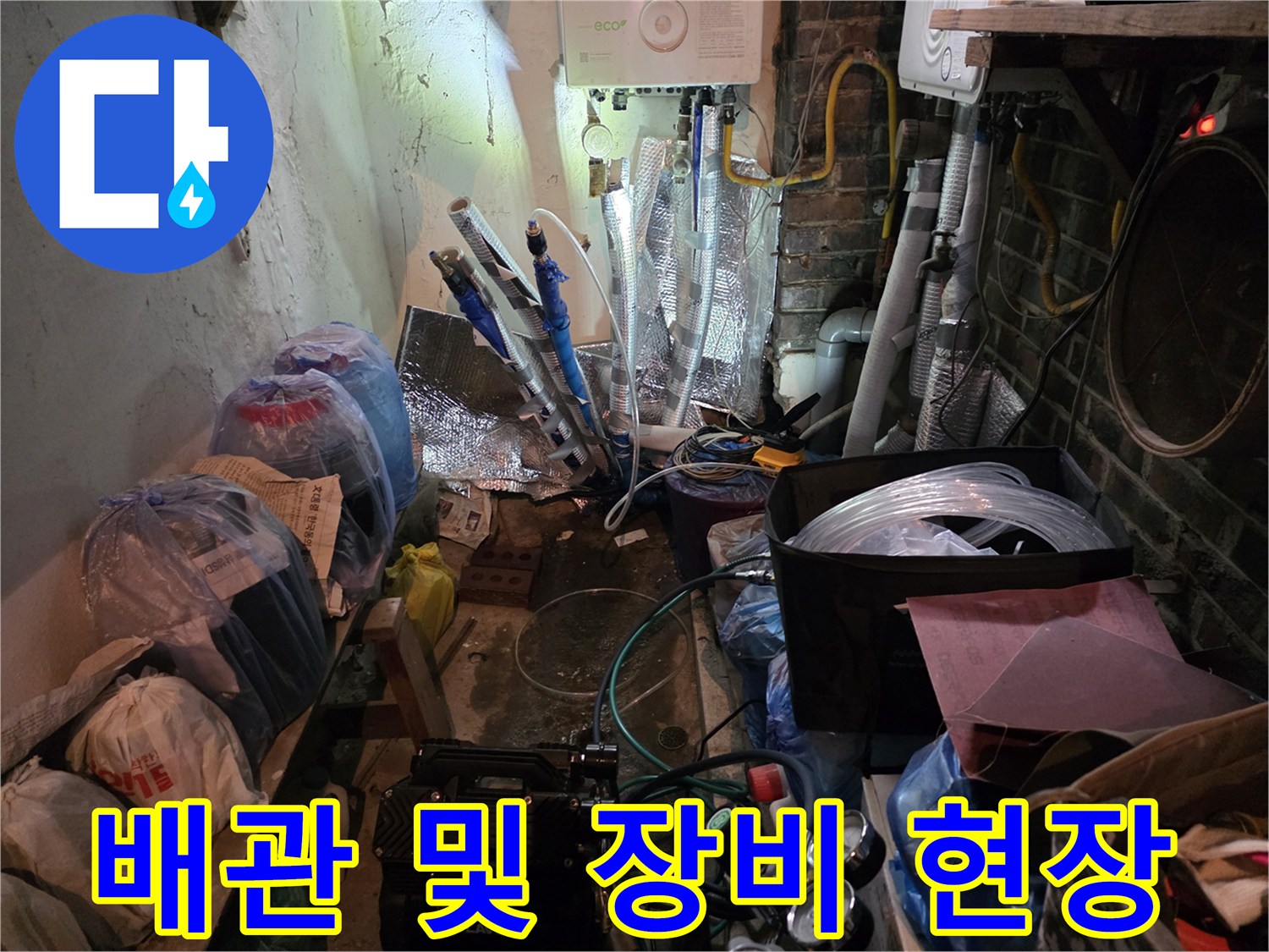 작업 준비물과 복잡한 배관이 보이는 보일러실 내부