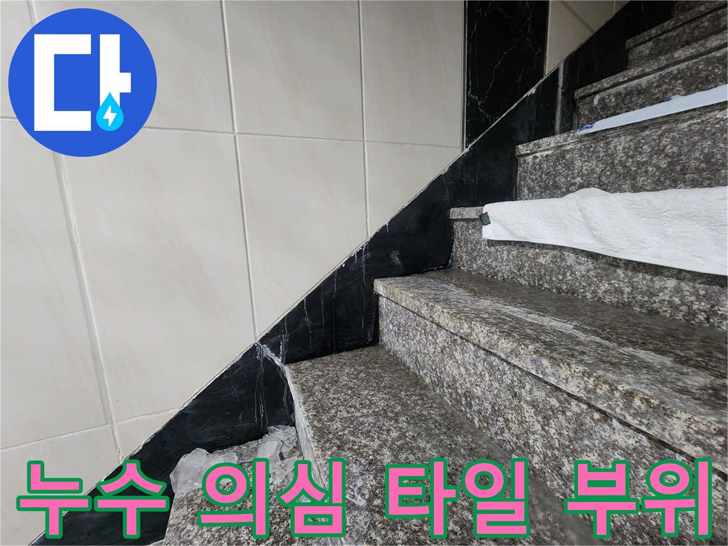 습기로 인해 어둡게 변한 계단 옆 벽면 타일 사진