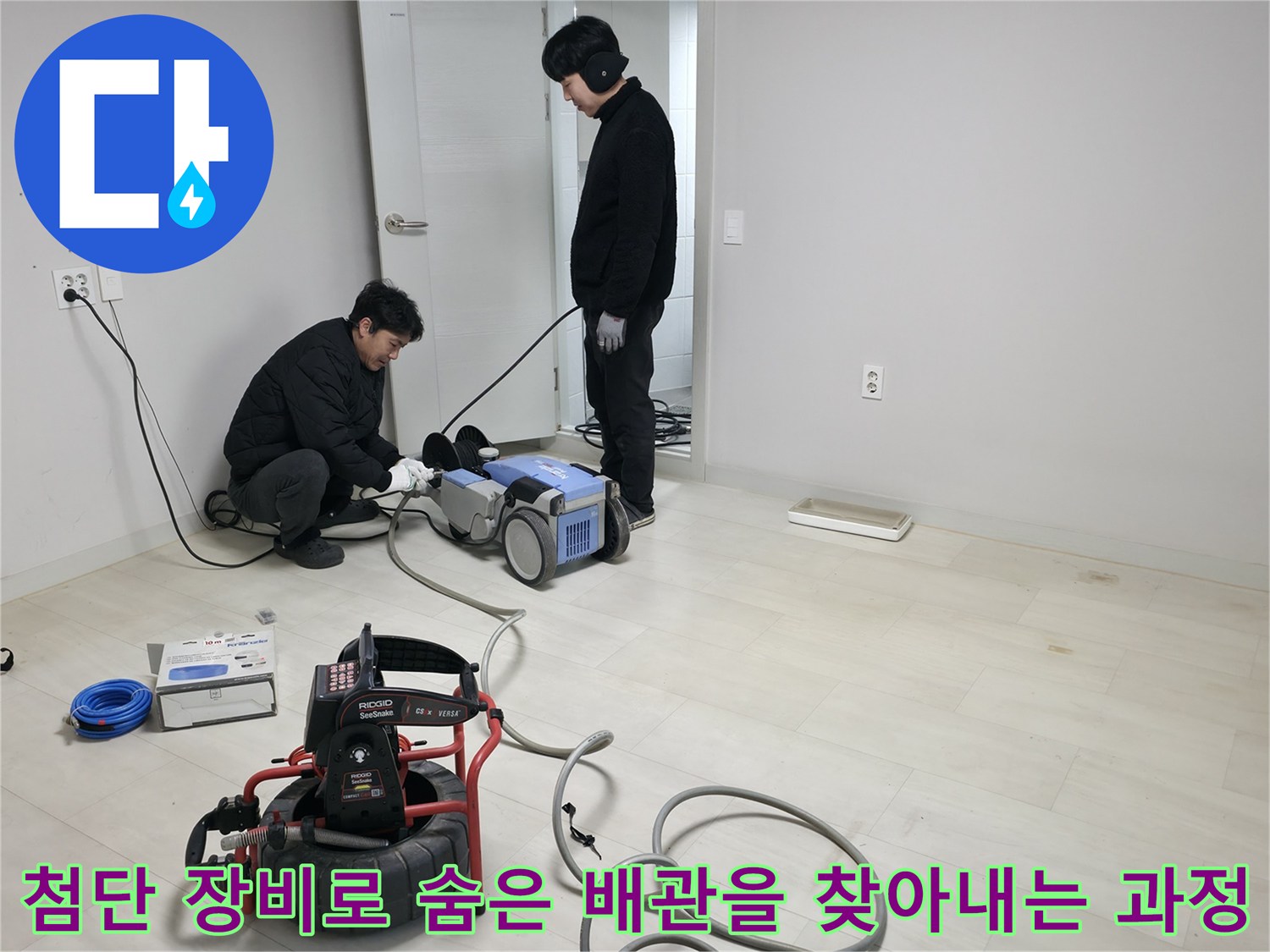 두 명의 기술자가 협력하여 청음 및 관로 탐지기로 바닥 하부 배관 구조를 정밀하게 파악하는 모습