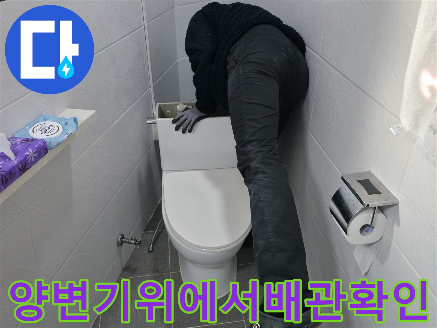 양변기 위에 엎드려 배관 상태를 점검하는 작업자 모습