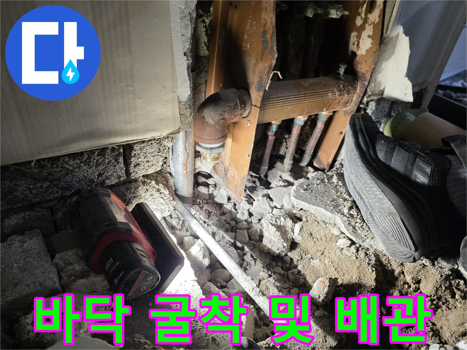 바닥을 파헤쳐 드러난 손상된 금속 배관과 주변 자재들