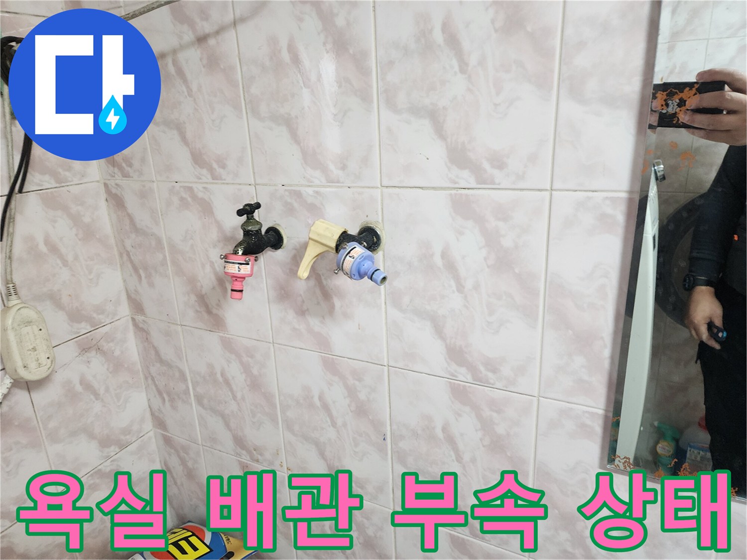 욕실 벽면 타일 사이로 노출된 노후된 수도 밸브와 연결 부품들