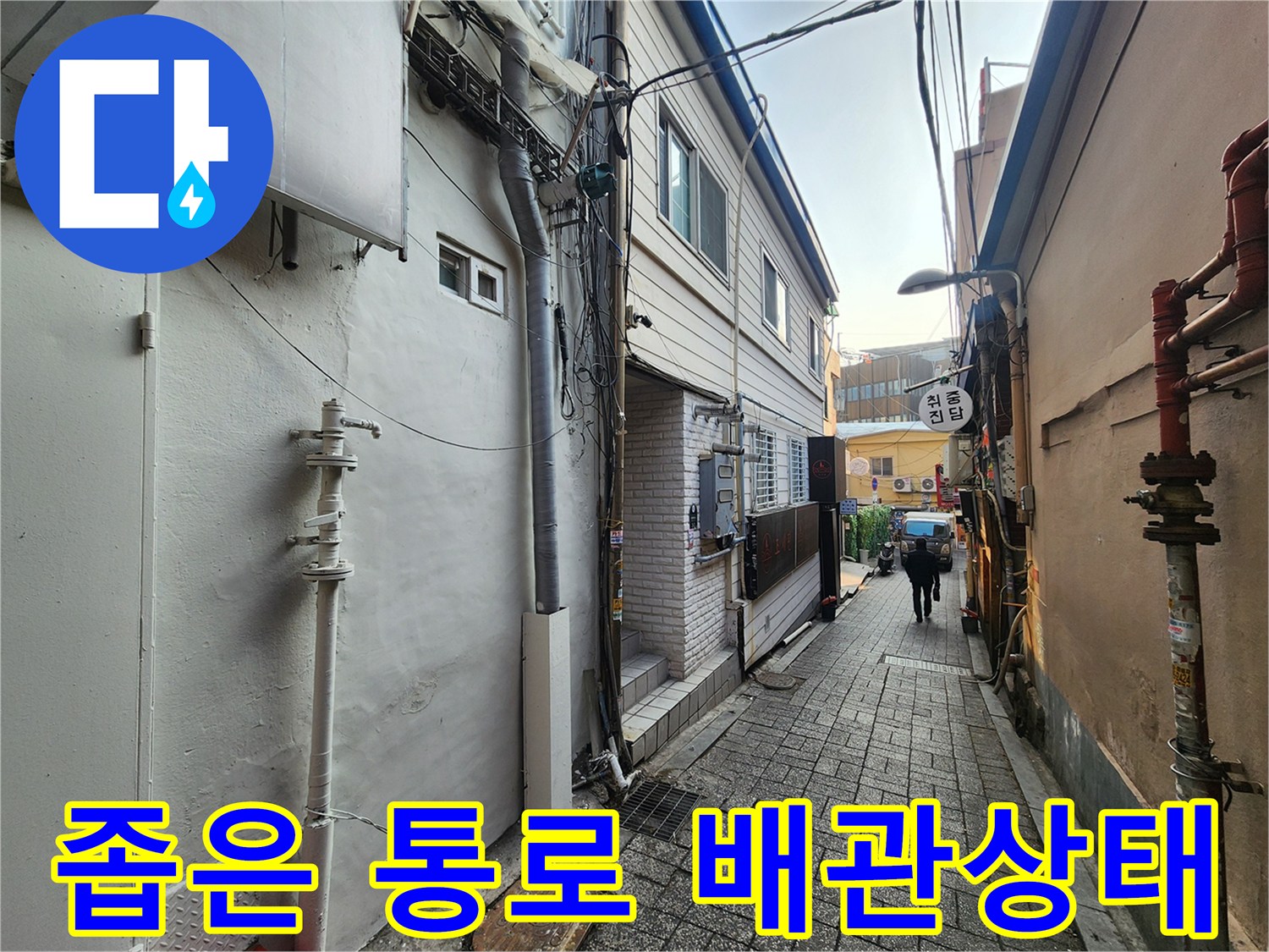건물 사이 좁은 통로에 위치한 복잡한 배관 라인
