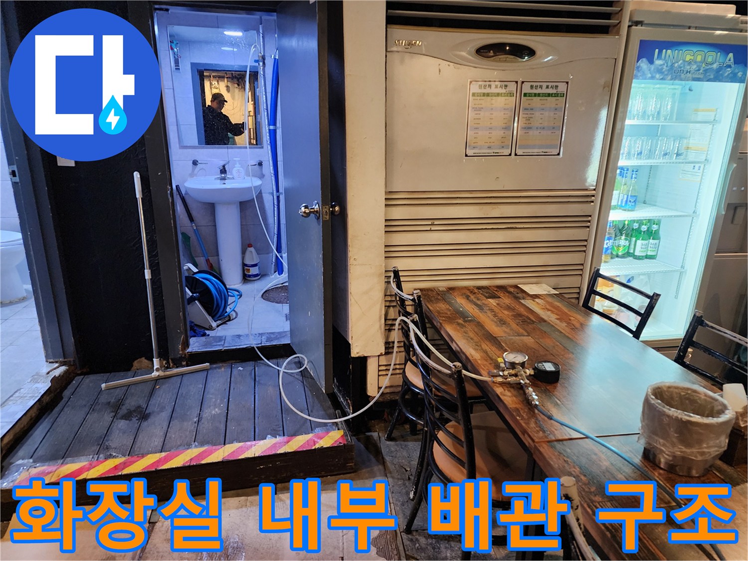 복잡하게 얽힌 파란색 주름관과 화장실 바닥 배관 모습
