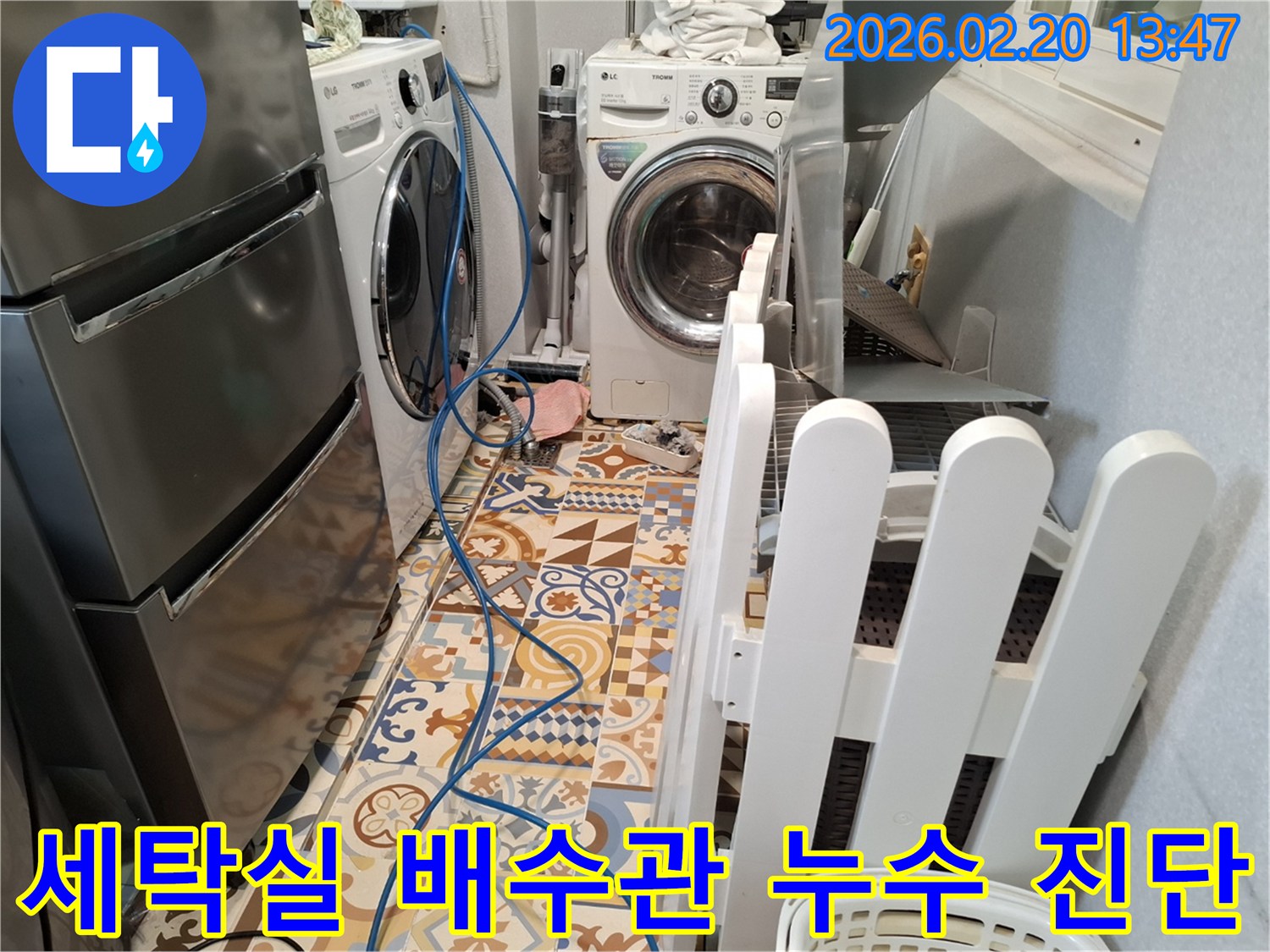 세탁실 바닥에 누수 탐지용 호스가 설치되어 있고-세탁기 주변을 집중적으로 점검하는 현장입니다.