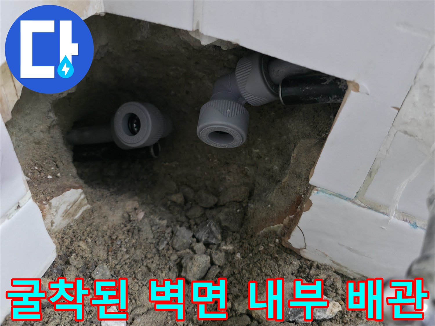 벽면 타일 제거 후 드러난 수도 배관과 연결 부속의 근접 촬영