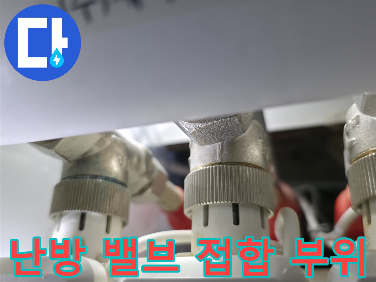 분배기 금속 밸브와 흰색 배관의 연결 지점 근접 촬영